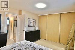 Bedroom with a closet, a textured ceiling, and light colored carpet - 
