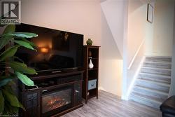 Living area with light wood finished floors and a glass covered fireplace - 