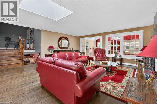 Living room with a skylight, wood finished floors, and a textured ceiling - 5590 Blind Line, Burlington, ON - Indoor Photo Showing Living Room