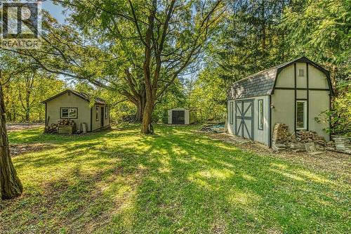 View of green lawn featuring a storage unit and view of scattered trees - 5590 Blind Line, Burlington, ON - Outdoor