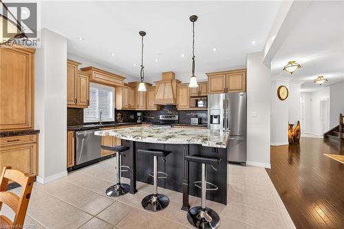 Kitchen with stainless steel appliances, light stone countertops, a kitchen bar, pendant lighting, and tasteful backsplash - 182 Irwin Avenue, Hamilton, ON - Indoor Photo Showing Kitchen With Upgraded Kitchen