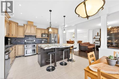 Kitchen featuring stainless steel appliances, a breakfast bar area, dark stone countertops, hanging lights, and a kitchen island - 182 Irwin Avenue, Hamilton, ON - Indoor Photo Showing Kitchen With Upgraded Kitchen