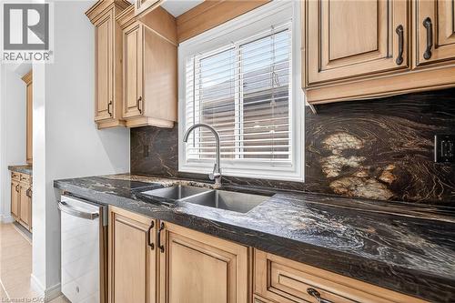 Kitchen with tasteful backsplash, dark stone counters, dishwasher, and light wood finish cabinets - 182 Irwin Avenue, Hamilton, ON - Indoor Photo Showing Kitchen With Double Sink With Upgraded Kitchen