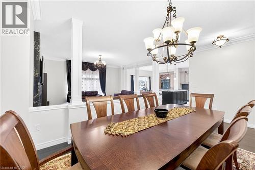Dining room with suspended lighting, crown molding, and wood finished floors - 182 Irwin Avenue, Hamilton, ON - Indoor Photo Showing Dining Room