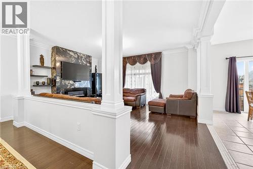 Living area with decorative columns, dark wood finished floors, and crown molding - 182 Irwin Avenue, Hamilton, ON - Indoor Photo Showing Other Room