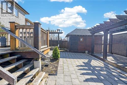 Fenced backyard featuring a wooden deck, an outdoor structure, and a patio - 182 Irwin Avenue, Hamilton, ON - Outdoor