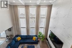 Living area with ornamental molding, dark wood-style flooring, and coffered ceiling - 