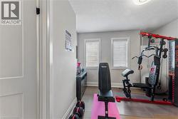 Exercise room featuring a textured ceiling and baseboards - 