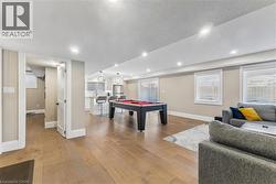 Playroom with a textured ceiling, billiards, and light wood-style floors - 