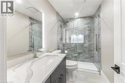 Full bath with vanity, a marble finish shower, and light tile patterned floors - 