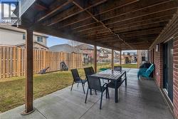 Fenced backyard with a patio, outdoor dining space, a grill, and a residential view - 
