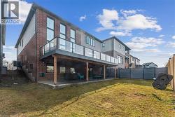 Rear view of property featuring a patio, brick siding, and a fenced backyard - 
