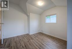 Additional living space featuring wood finished floors and baseboards - 