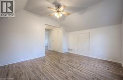 Additional living space featuring ceiling fan, wood finished floors, and vaulted ceiling - 