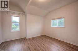 Unfurnished room with light wood finished floors and vaulted ceiling - 