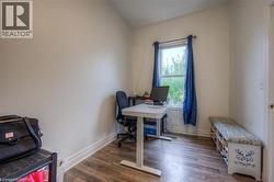 Office space with dark wood-type flooring and baseboards - 