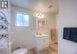 Full bath featuring vanity and light tile patterned floors - 