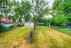Fenced backyard featuring a storage unit - 
