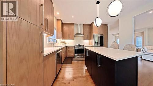 Kitchen with a center island, light wood-type flooring, stainless steel appliances, modern cabinets, and open floor plan - 63 Ian Ormston Drive, Kitchener, ON - Indoor Photo Showing Kitchen With Upgraded Kitchen