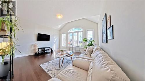 Living area featuring lofted ceiling and dark wood finished floors - 63 Ian Ormston Drive, Kitchener, ON - Indoor Photo Showing Living Room