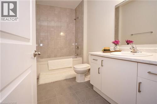Bathroom featuring vanity, dark tile patterned floors, and  shower combination - 63 Ian Ormston Drive, Kitchener, ON - Indoor Photo Showing Bathroom
