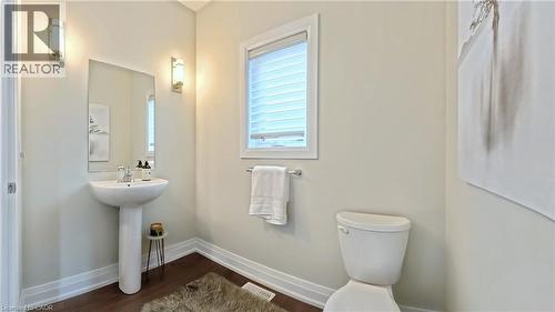 Half bathroom with baseboards and dark wood-type flooring - 63 Ian Ormston Drive, Kitchener, ON - Indoor Photo Showing Bathroom