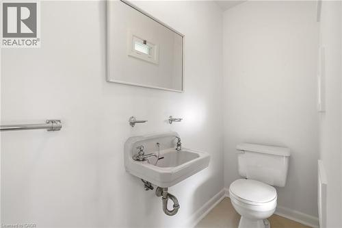 Half bath featuring toilet and baseboards - 890 Falcon Boulevard, Burlington, ON - Indoor Photo Showing Bathroom
