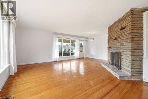 Unfurnished living room featuring light wood finished floors, a fireplace, and crown molding - 890 Falcon Boulevard, Burlington, ON - Indoor Photo Showing Living Room With Fireplace