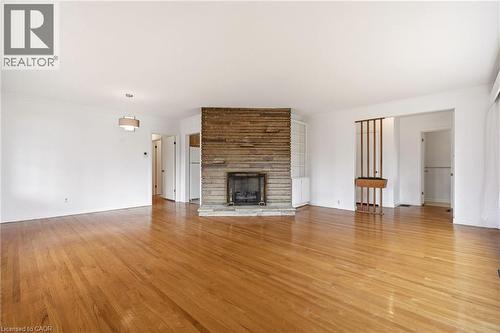 Unfurnished living room featuring light wood-type flooring, crown molding, and a fireplace - 890 Falcon Boulevard, Burlington, ON - Indoor Photo Showing Living Room With Fireplace