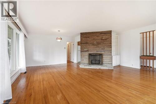 Unfurnished living room with light wood-style flooring, a fireplace, and ornamental molding - 890 Falcon Boulevard, Burlington, ON - Indoor Photo Showing Living Room With Fireplace