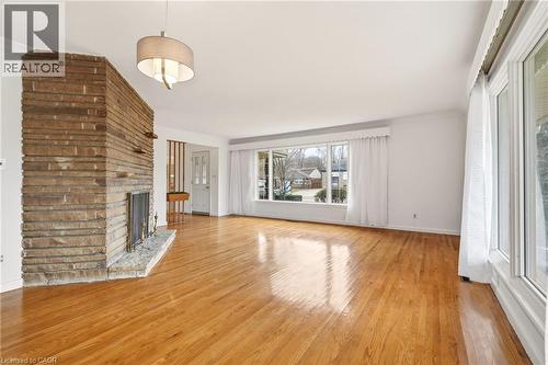 Unfurnished living room featuring ornamental molding, light wood finished floors, and a fireplace - 890 Falcon Boulevard, Burlington, ON - Indoor Photo Showing Living Room With Fireplace