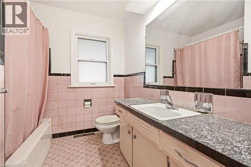 Bathroom featuring wainscoting, vanity, light tile patterned floors, tile walls, and shower / bathtub combination with curtain - 890 Falcon Boulevard, Burlington, ON - Indoor Photo Showing Bathroom