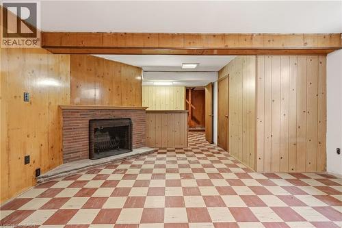 Finished basement with light flooring, a brick fireplace, and wooden walls - 890 Falcon Boulevard, Burlington, ON - Indoor With Fireplace