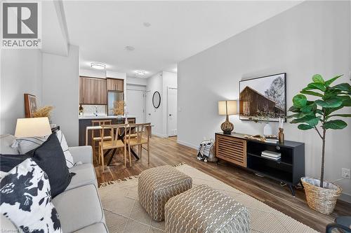 Living room featuring vinyl plank flooring and flows nicely to dining and kitchen. - 2081 Fairview Street Unit# 1402, Burlington, ON - Indoor Photo Showing Living Room