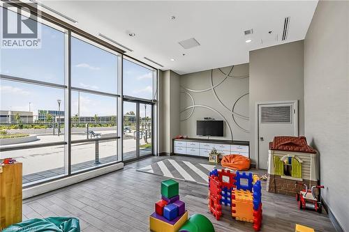 Kids playroom complete with toys and access to outdoor lounging space. - 2081 Fairview Street Unit# 1402, Burlington, ON - Indoor Photo Showing Other Room