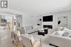 Living area featuring light wood finished floors, a high end fireplace, and recessed lighting - 