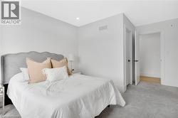 Bedroom featuring light colored carpet and baseboards - 