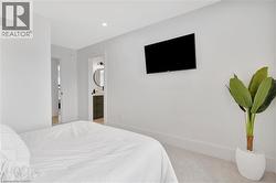 Bedroom featuring light carpet, ensuite bathroom, and recessed lighting - 