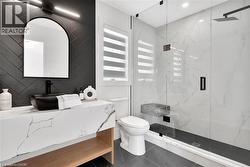 Bathroom featuring vanity and a marble finish shower - 