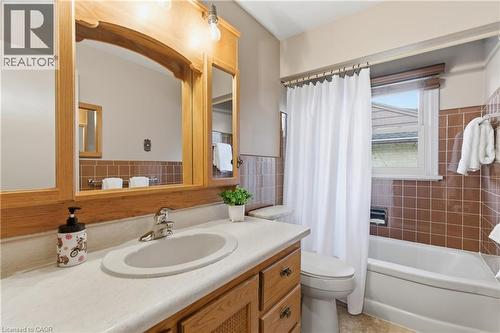 Bathroom with vanity, shower / bath combination with curtain, tile walls, and a wainscoted wall - 135 Burbank Road, Kitchener, ON - Indoor Photo Showing Bathroom