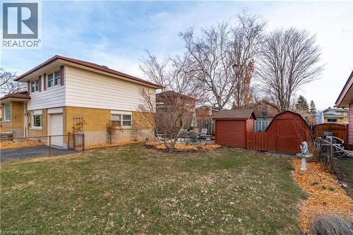 Fenced backyard with a storage unit, a garage, and driveway - 135 Burbank Road, Kitchener, ON - Outdoor