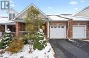 View of front of house featuring asphalt driveway, a garage, brick siding, and a porch - 92 Schroder Crescent, Guelph, ON  - Outdoor 