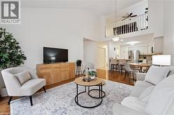 Living room with light wood-style floors, ceiling fan, and high vaulted ceiling - 