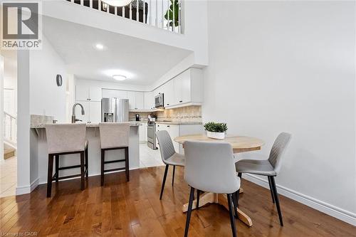 Dining area with light wood-type flooring, a high ceiling, and stairway - 92 Schroder Crescent, Guelph, ON - Indoor Photo Showing Dining Room