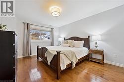 Bedroom featuring hardwood / wood-style floors and baseboards - 