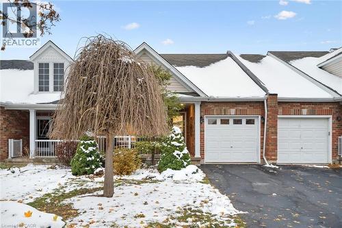 View of front of property with brick siding, driveway, an attached garage, and a porch - 92 Schroder Crescent, Guelph, ON - Outdoor