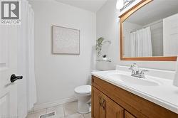 Bathroom featuring vanity, light tile patterned floors, and curtained shower - 