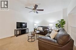 Living area with light carpet and ceiling fan - 