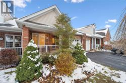 View of front facade featuring brick siding, a porch, driveway, and a garage - 