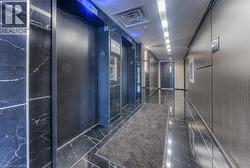 Hallway featuring elevator and dark marble finish flooring - 